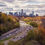 Multi-lane highway leading toward a city skyline