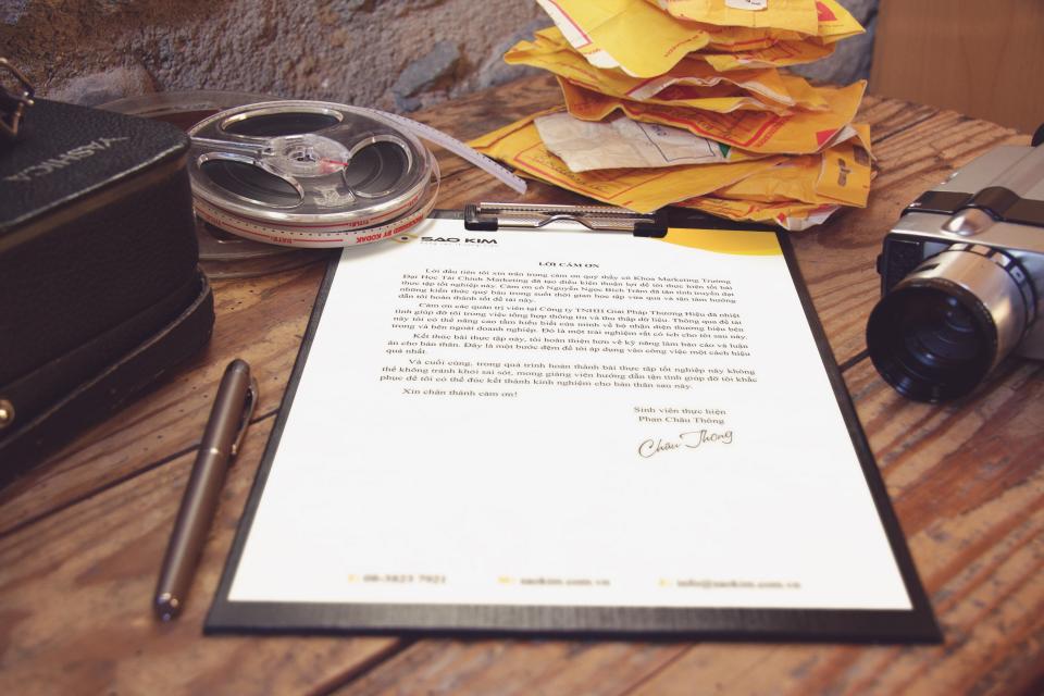 A signed document on a clipboard beside a pen