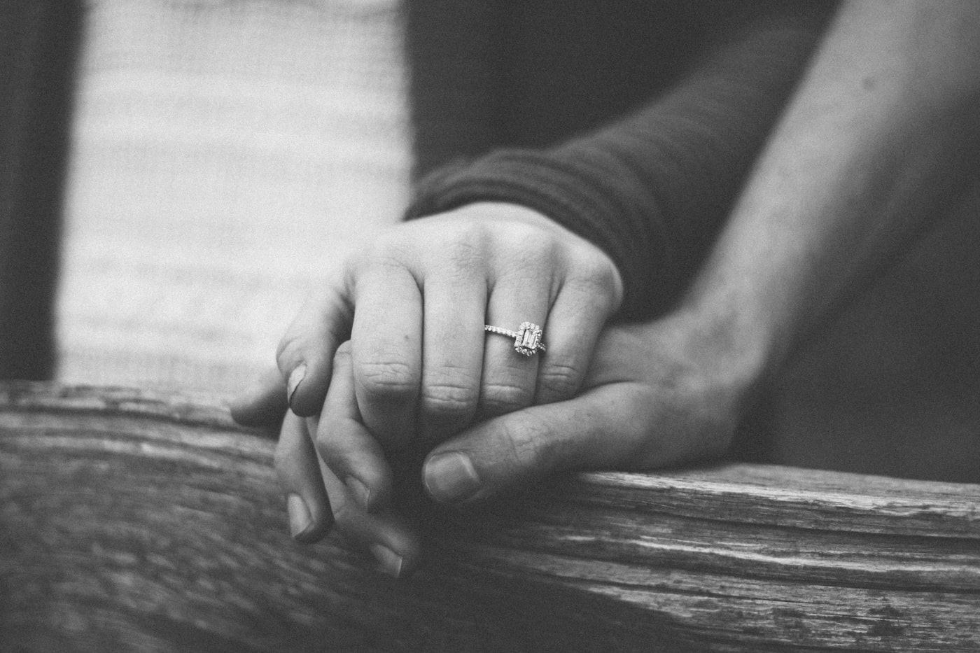 A married couple holding hands, wedding ring visible